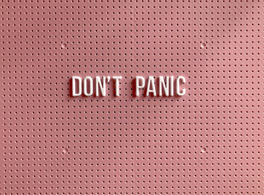 fear of AI. Don't Panic text on pink and white polka dot background.  